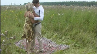 Юной человек в поле развлекается в обществе взрослой соседки